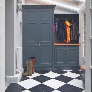 Navy utility room with statement black and white floor tiles.
