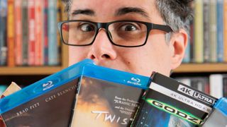 CGI in movies; a man looks over the top of a selection of Blu-ray cases 