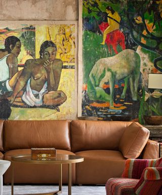 A living room with mural-sized artwork, a brown leather couch and a round glass coffee table