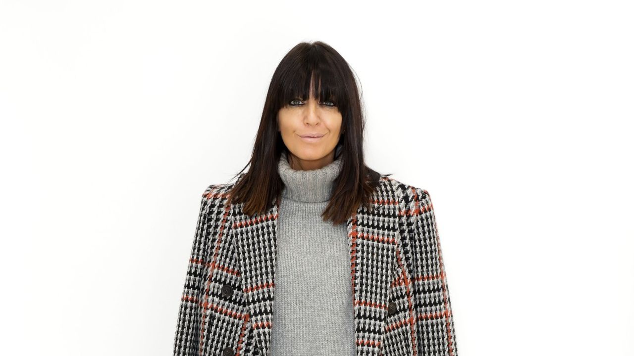 Claudia Winkleman poses in a jumper and a blazer