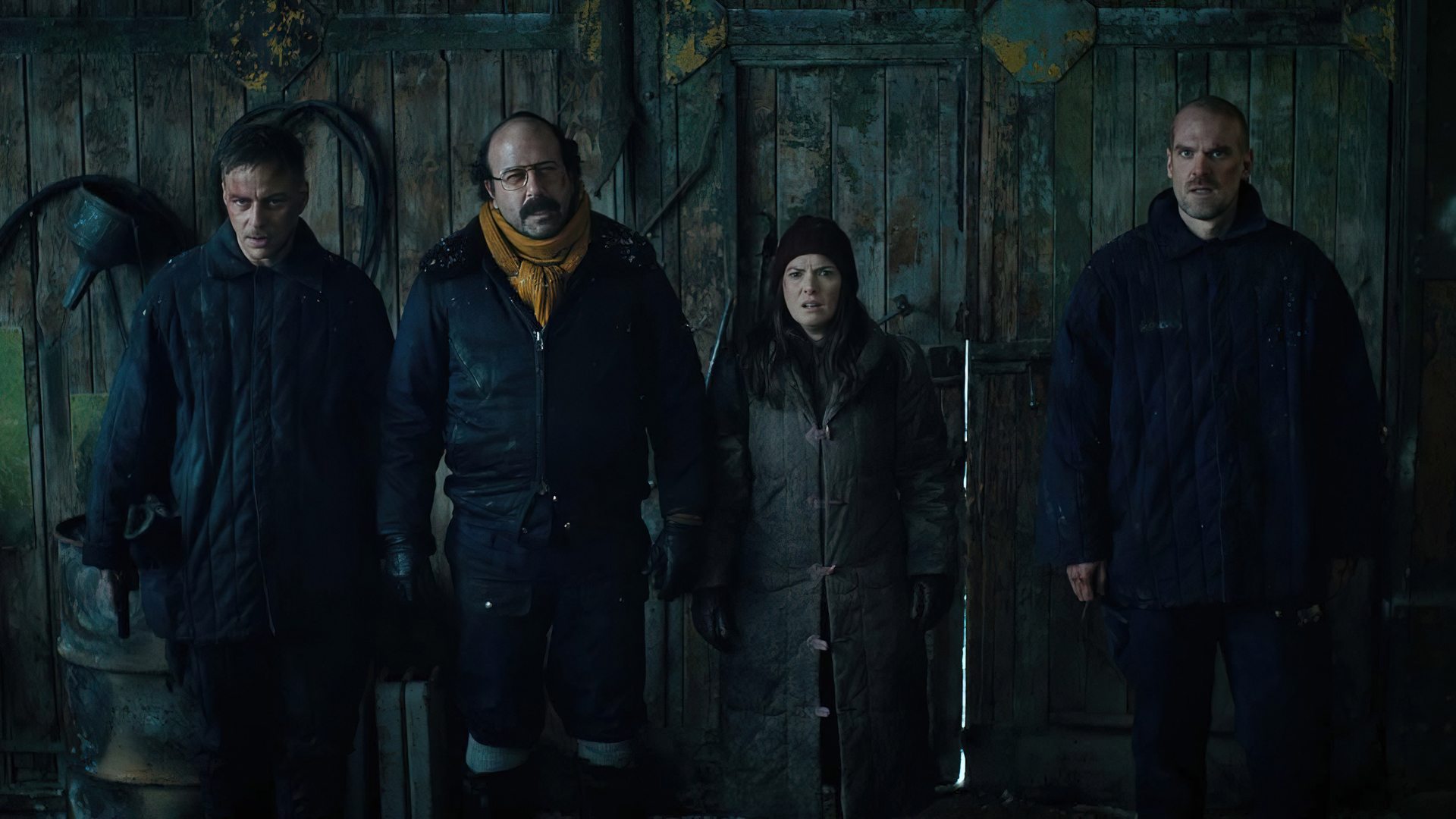 Hopper, Joyce, Murray and Dmitri enter a barn and stare at someone off screen in Stranger Things season 4