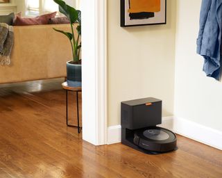 iRobot Roomba J7+ in hallway with charging dock on laminate wooden flooring