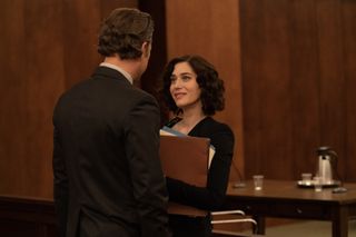 Lizzy Caplan as Alex Forrest and Joshua Jackson as Dan Gallagher in Fatal Attraction. They are standing in a courtroom - he has his back to the camera and she is holding several folders and looking up into his eyes brightly