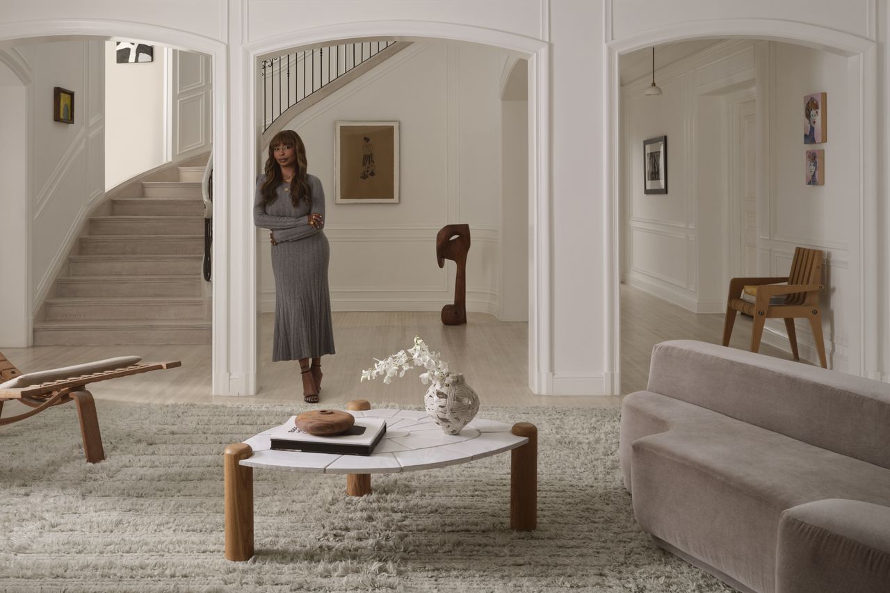 Designer Brigette Romanek leans against a wall in her Los Angeles homee