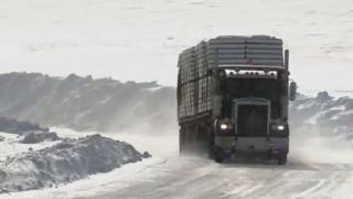 A truck driving on an ice road during the intro of Ice Road Truckers