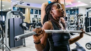 Woman performs lat pull-down