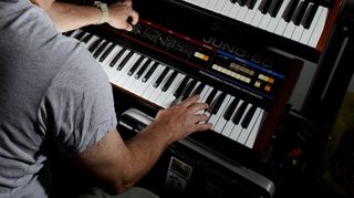 man playing chords on synthesisers