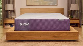 The Purple Restore Hybrid mattress on a wooden bed frame in a bedroom