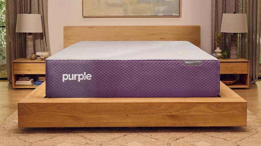 The Purple Restore Hybrid mattress on a wooden bed frame in a bedroom