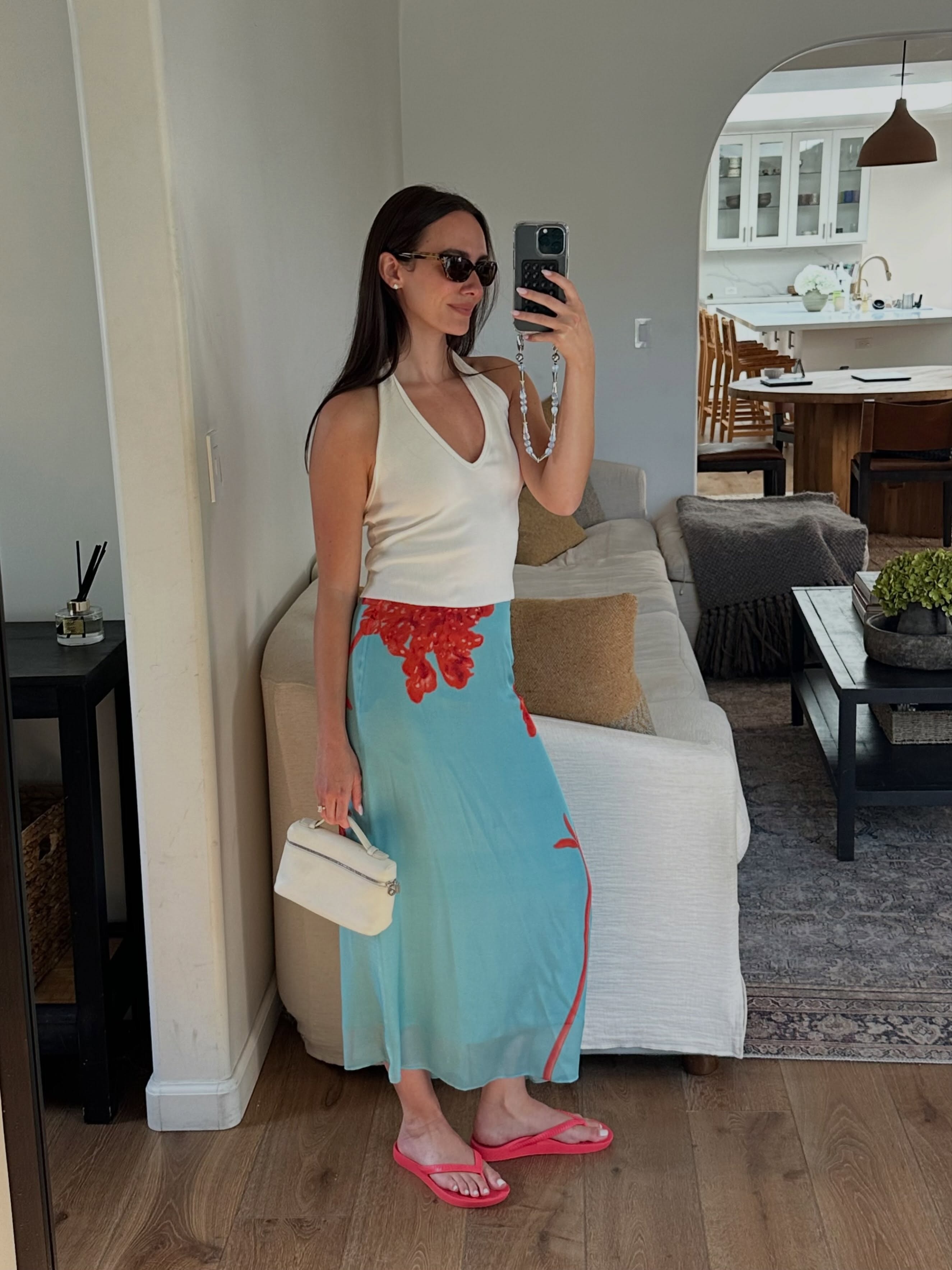 Liv Perez wearing a white tank, blue midi skirt, and red flip-flops