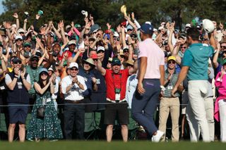 Morikawa and McIlroy raise their hats in front of the patrons at Augusta National