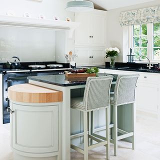 kitchen area with white wall and granite worktop with chairs