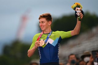 Tadej Pogacar shows off his bronze medal on the podium of the men's road race at the Tokyo Olympics