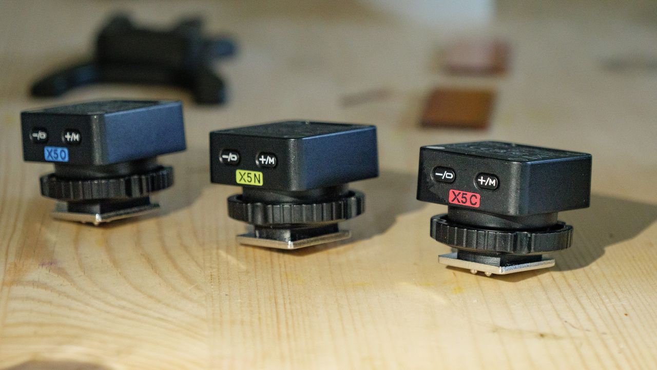 Three Godox X5 remote triggers for the iT32 camera flash on a wooden table