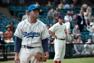 chadwick boseman as jackie robinson in his dodgers uniform on the baseball field in 42