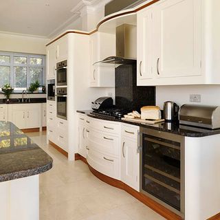 kitchen with pale marble floor tiles and cream units