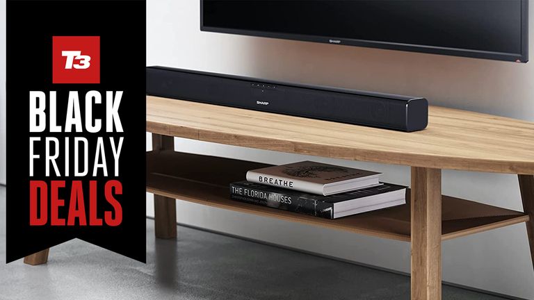 Sharp HT-SB110 soundbar in living room under a TV with sign saying Black Friday deals