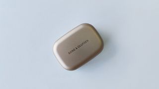 Bang & Olufsen Beoplay EX review: earbuds case from above on white desk