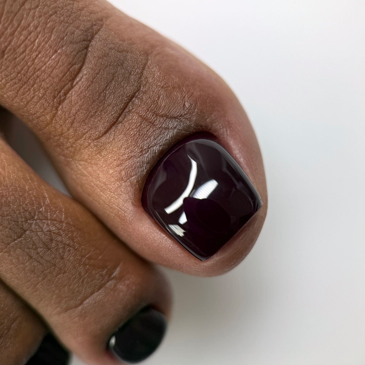 A picture of a glossy, dark brown pedicure