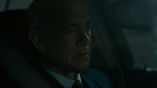 Tom Hanks sits in a dark garage in his car in A Man Called Otto