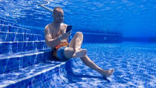 A person using an iPhone in a swimming pool