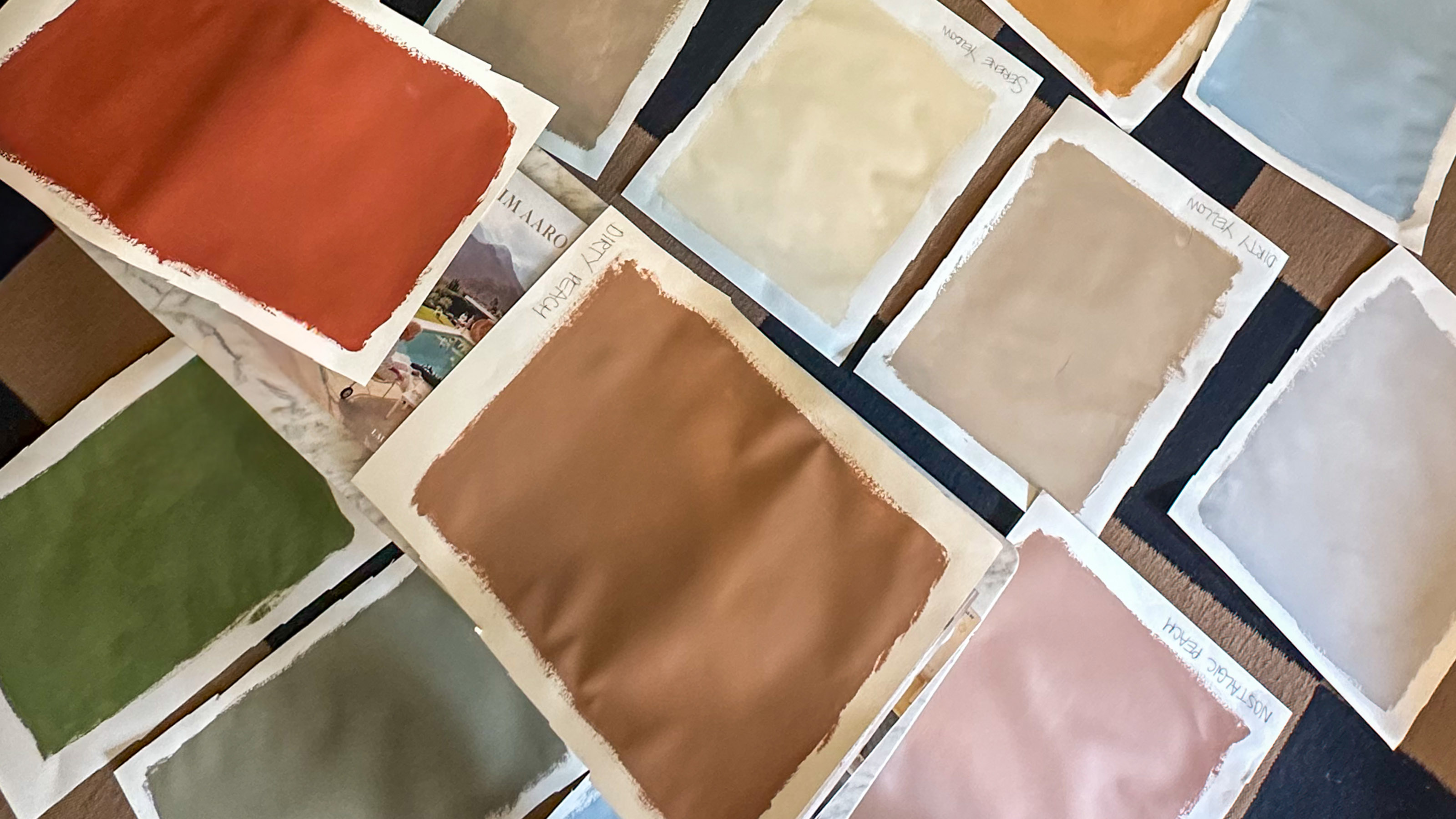 red, green and beige colour swatches laid out on a desk