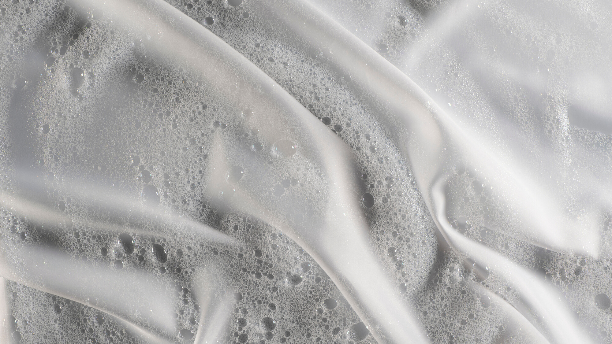 Soapy bubbles on a white silk bedding fabric