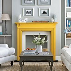 Grey painted feature wall in living room with yellow fireplace