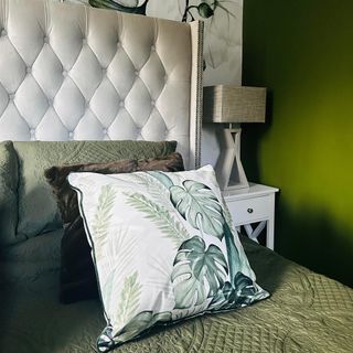 bed with green floral cushion