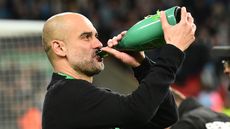 Man City manager Pep Guardiola drinks champagne as he celebrates the Carabao Cup win