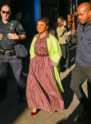 another angle of Quinta Brunson's burgundy dress and lime green coat