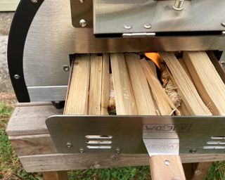 lighting the kindling in the fuel tray of the Woody pizza oven