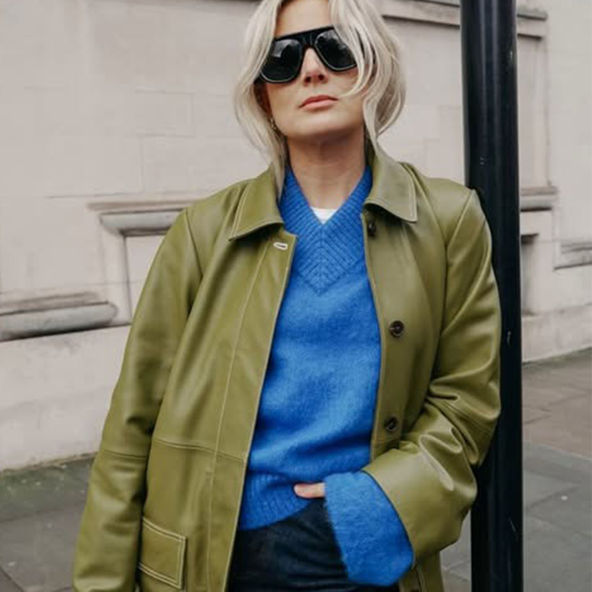 Woman in a blue sweater, green jacket, and jeans