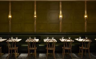 Booth seating, tables and chairs line the wooden paneled walls