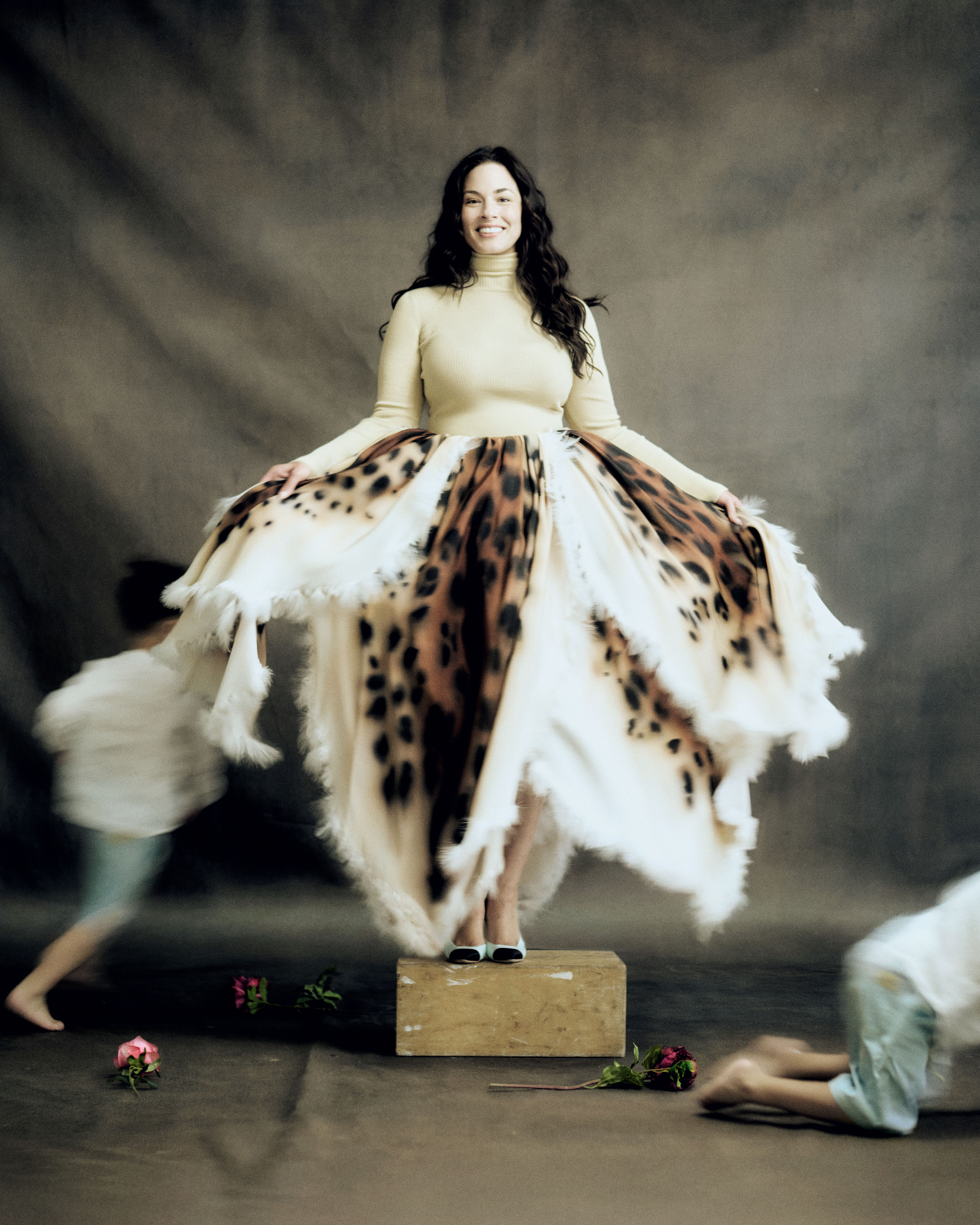 Ashley Graham poses for our photo shoot, as her twin boys run around