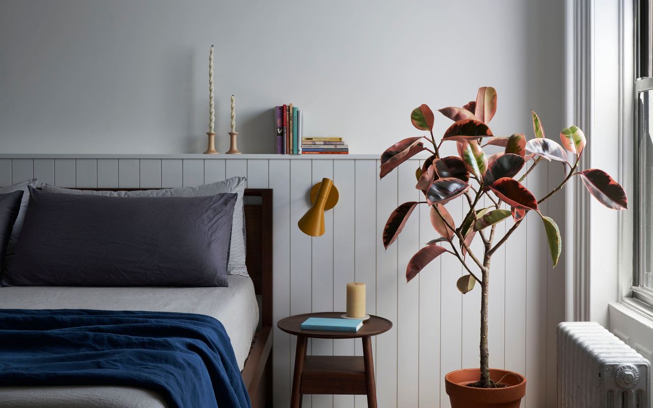 A cozy bedroom with two types of candle and wall light