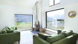 living room with large picture windows and green sofas