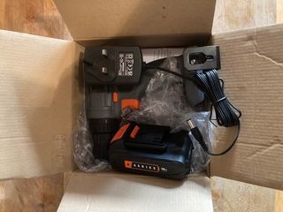A cardboard box filled with VonHaus charger, battery and drill