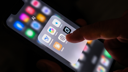 A close up of a hand touching a series of apps on a smartphone