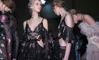 Female models wearing decorative black lace dresses