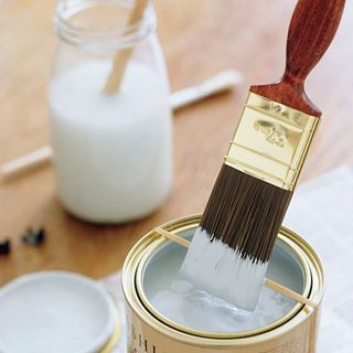 white paint and paint brush with glass jar