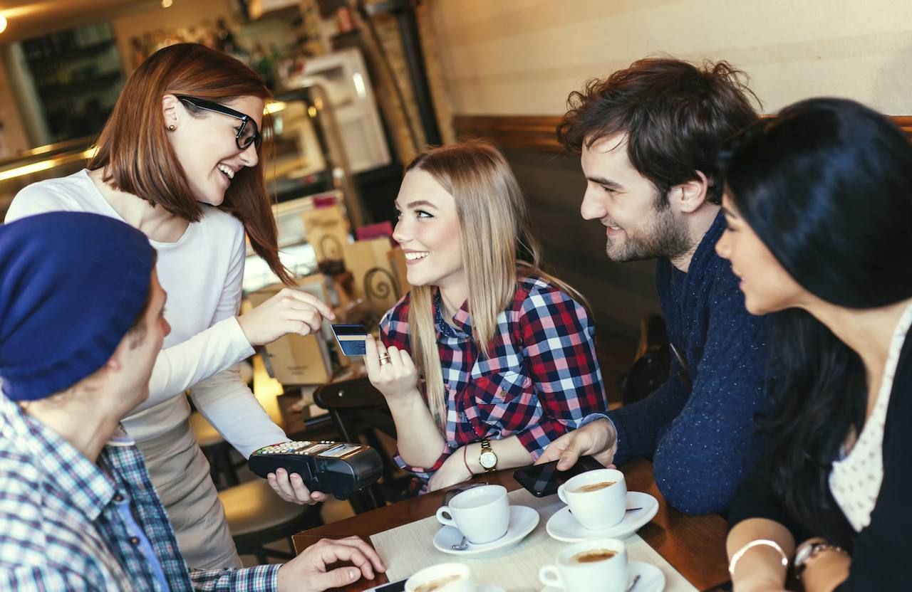 Young Woman Paying A Bill By Credit Card