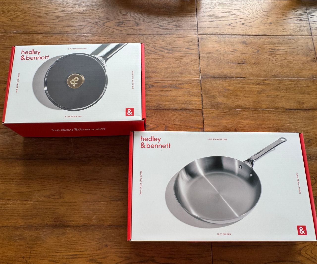 Two boxes for pans, one stainless steel frying pan, one stainless steel sauce pan