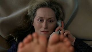Meryl Streep talks on the phone with her toes filling the bottom of the frame