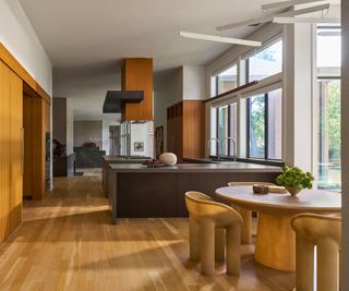 view from eat-in kitchen round table towards kitchen with dark cabinets