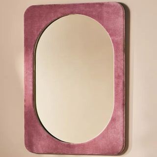 A blush pink velvet wall mirror