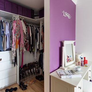 dressing area with purple wall and hanging cloths with shoes storage