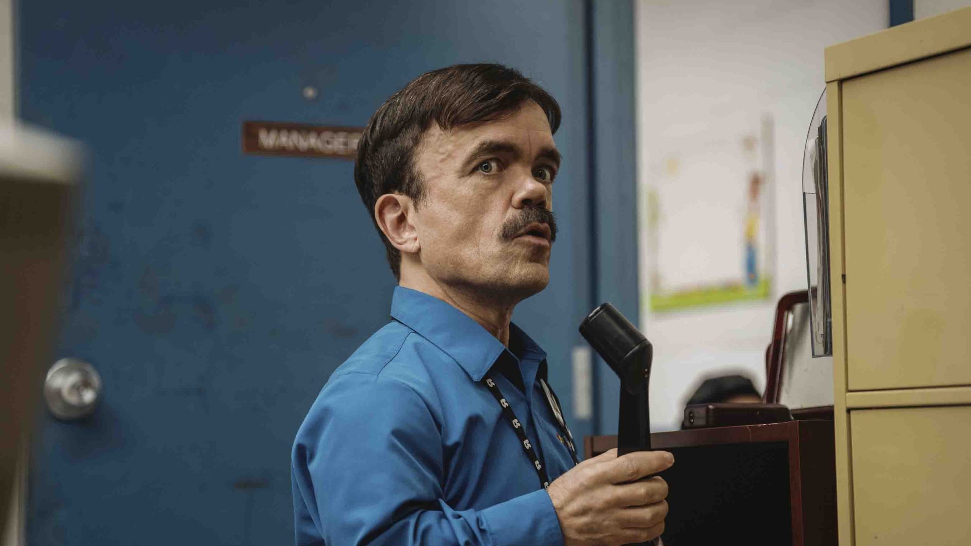 Peter Dinklage holding a microphone in Roofman
