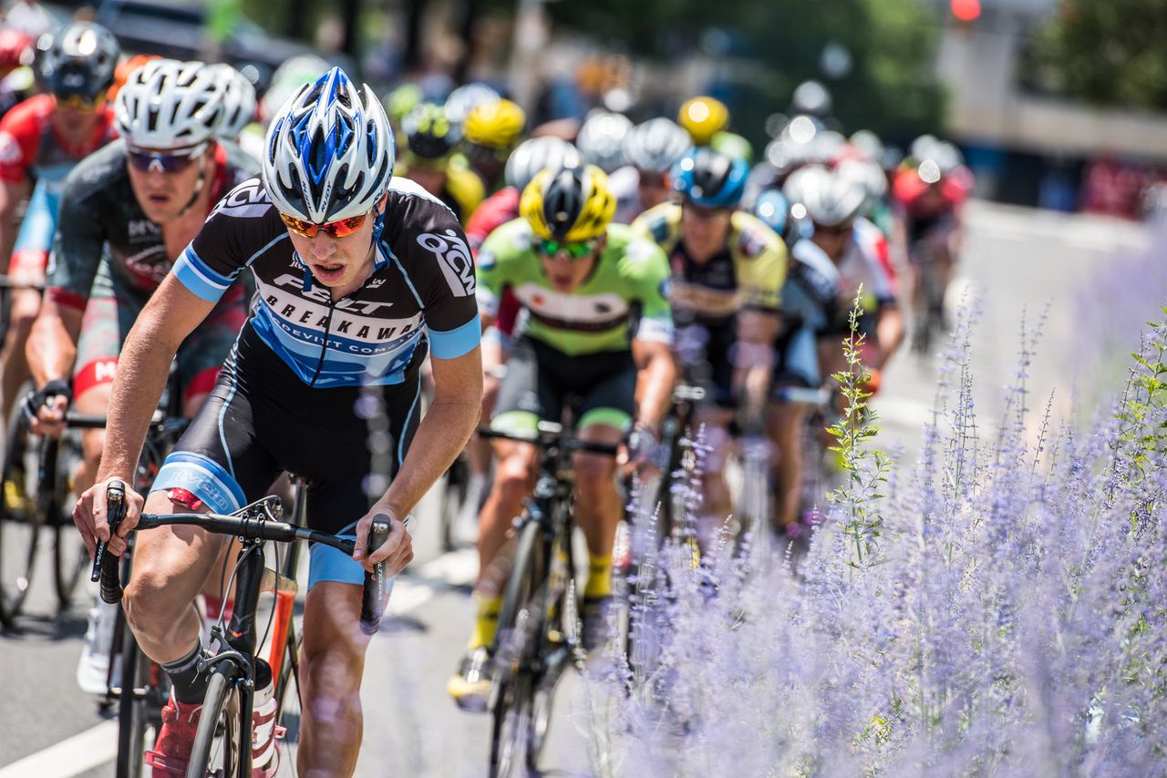 Riders pass by flowers along the course