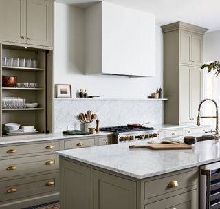 A kitchen with dark green caibents and white walls